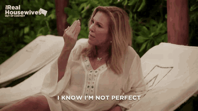a woman is laying on a lawn chair and says i know i 'm not perfect