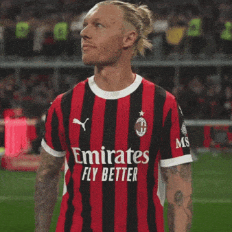 a soccer player wearing a jersey that says emirates fly better on it