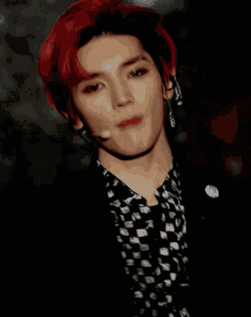a man with red hair is wearing earrings and a microphone