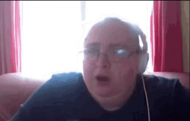 a man wearing headphones is sitting on a couch .