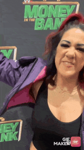 a woman with red hair is standing in front of a money in the bank sign .