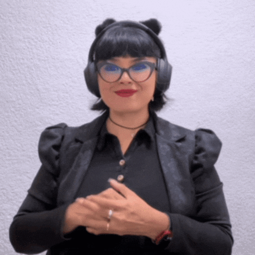 a woman wearing headphones and glasses is smiling for the camera