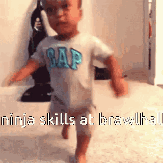 a baby in a gap shirt is walking on the floor