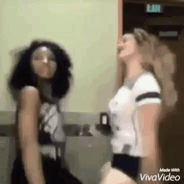 a couple of women are dancing in a room .