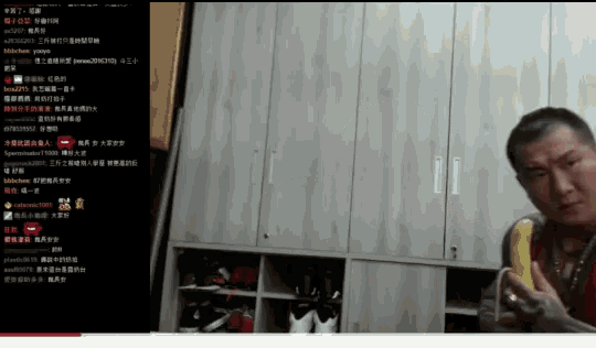 a man is eating a banana in front of a closet with chinese writing on it