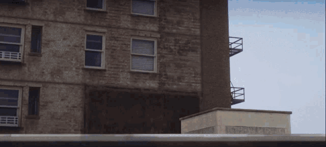 a brick building with a balcony and stairs on the side