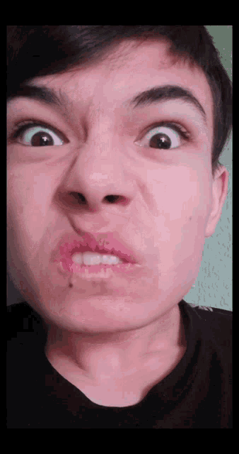 a close up of a person 's face with a black shirt on