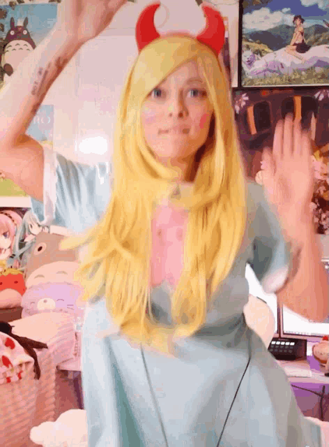 a girl in a star vs the forces of evil costume waves her hand