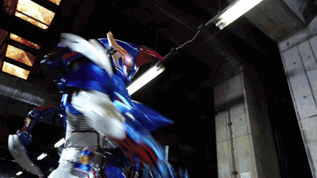 a person in a blue and white robot costume is standing in a dark room