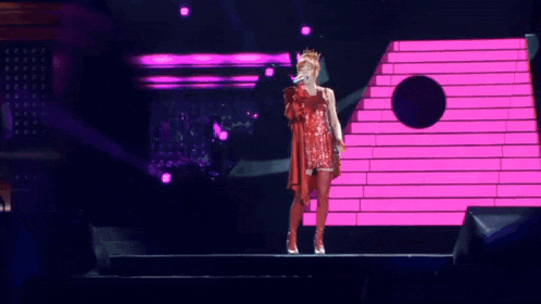 a woman singing into a microphone on a stage