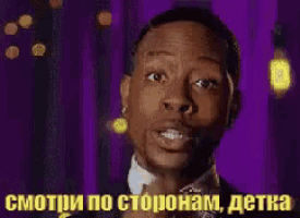 a man in a tuxedo and bow tie is pointing at something in a foreign language .