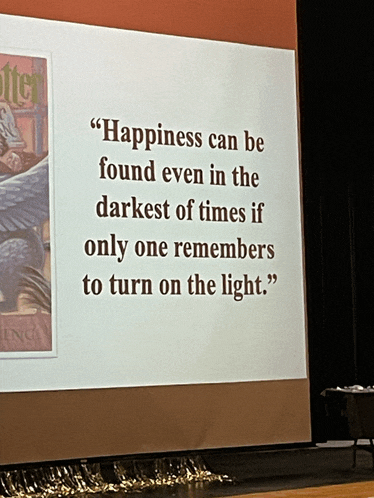 a projector screen displays a quote about happiness