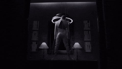 a black and white photo of a person standing in front of a circle