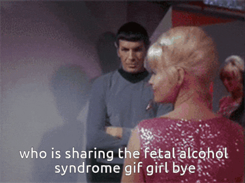 a woman in a pink dress talks to a man in a blue shirt