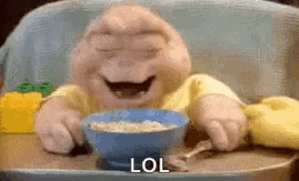 a baby is sitting in a high chair with a bowl of cereal and the words lol written on the bottom