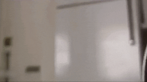 a close up of a toilet seat in a bathroom with a door in the background .