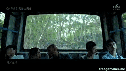 a group of people are sitting on a bus with the word him on the bottom left