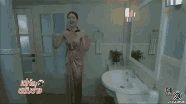a woman in a pink dress is dancing in a bathroom with the number 3 on the bottom left
