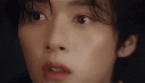 a close up of a person 's face with a surprised look on her face