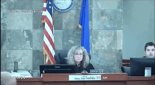 a woman sits at a desk with a sign that says mary key melvin on it