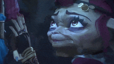 a close up of a cartoon character 's face with a skeleton hand behind her
