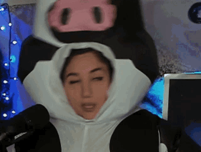 a woman is wearing a cow costume with a pig on top of her head .