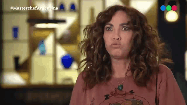 a woman with curly hair is making a funny face while wearing a t-shirt that says " snoopy "
