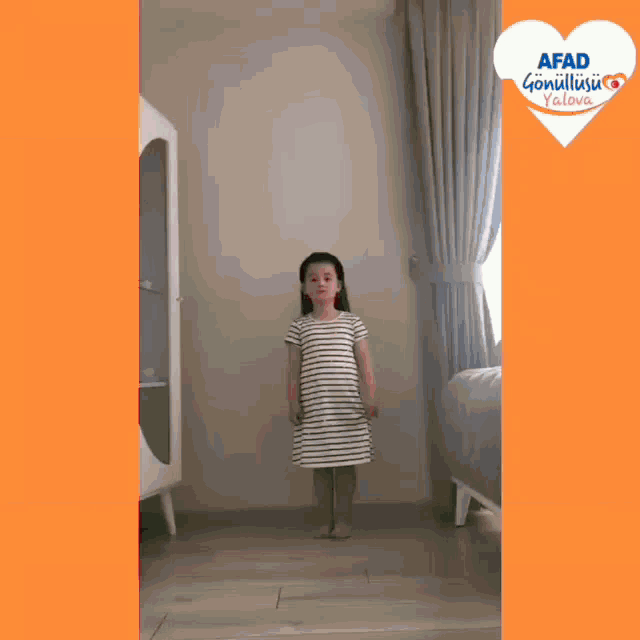 a little girl in a striped dress is standing in a room with an afad logo