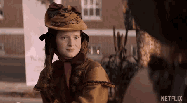a woman wearing a hat with the word netflix on the bottom right
