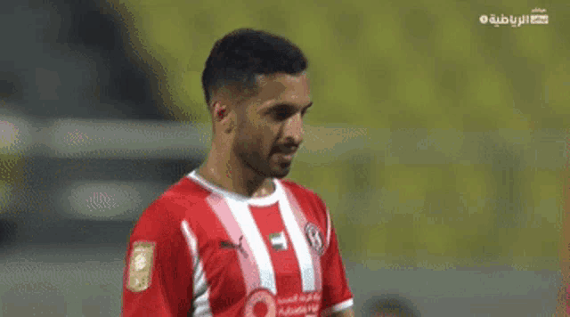 a soccer player wearing a red and white jersey with a vodafone logo on the front