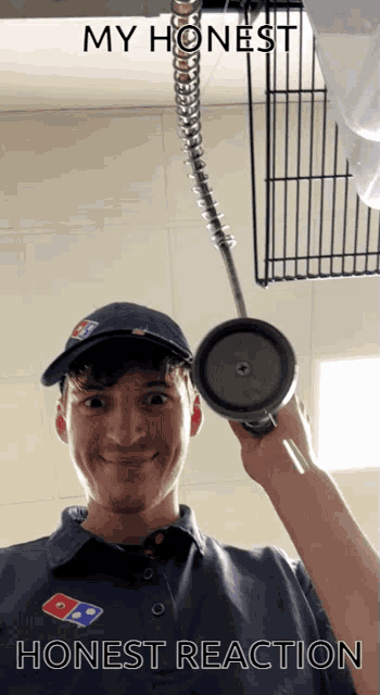 a man wearing a domino 's shirt is holding a cup in his hand