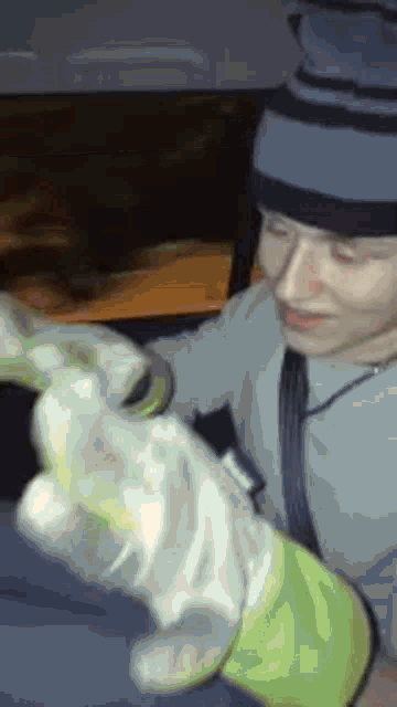 a man wearing a hat and gloves is holding something in his hands .