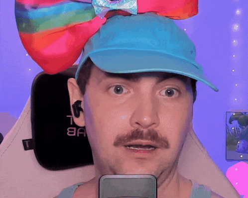 a man wearing a blue hat with a rainbow bow on top