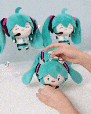 a person is playing with a stuffed hatsune miku toy