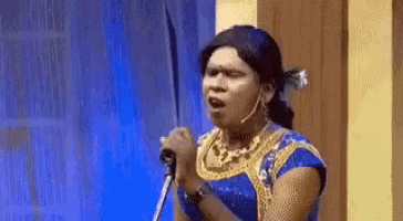 a woman is singing into a microphone while wearing a wig .