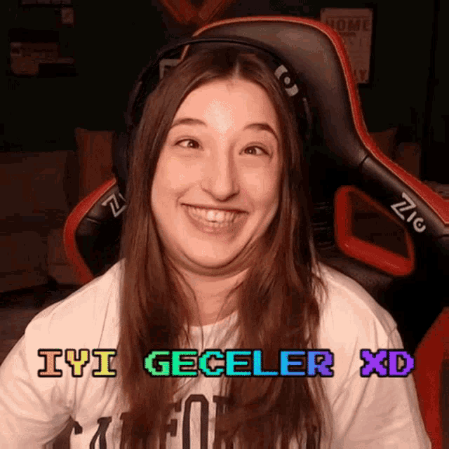 a woman wearing headphones and a shirt that says iyi geceler xd smiles