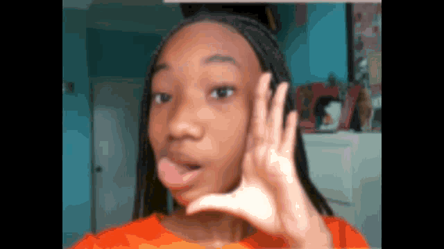 a young girl making a funny face with her hand on her face