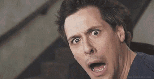 a man is making a surprised face with his mouth open and his eyes wide open .