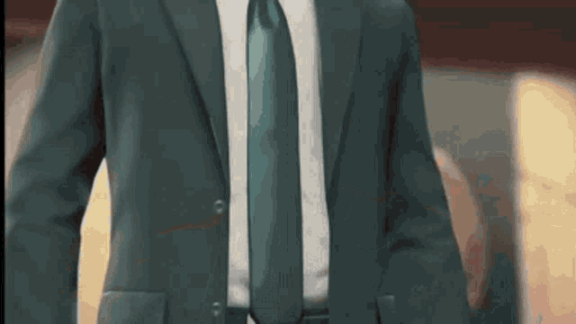 a man in a suit and tie is standing in a room in a video game .