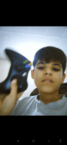 a young boy holding a video game controller in his hand