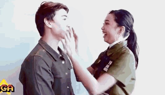 a man and a woman are touching each other 's faces and laughing .