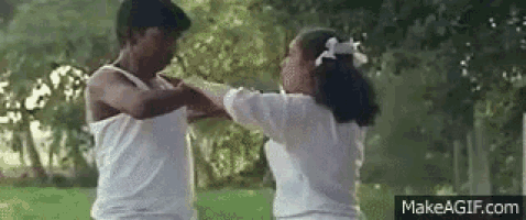a man and woman are dancing in a park .