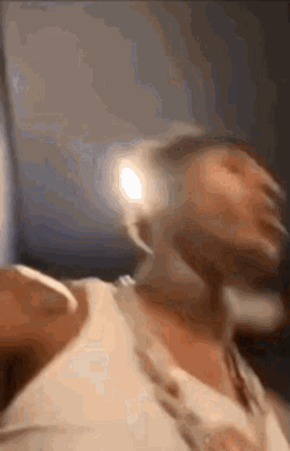a blurry picture of a man 's face with a light shining on it .
