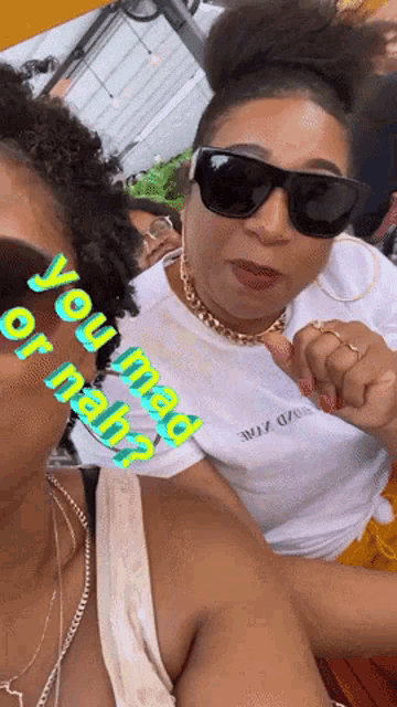 two women wearing sunglasses and a t-shirt that says ' you mad or nah ' on it