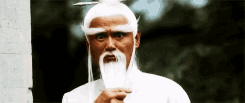 a man with a long white beard and a white wig is holding a fan .