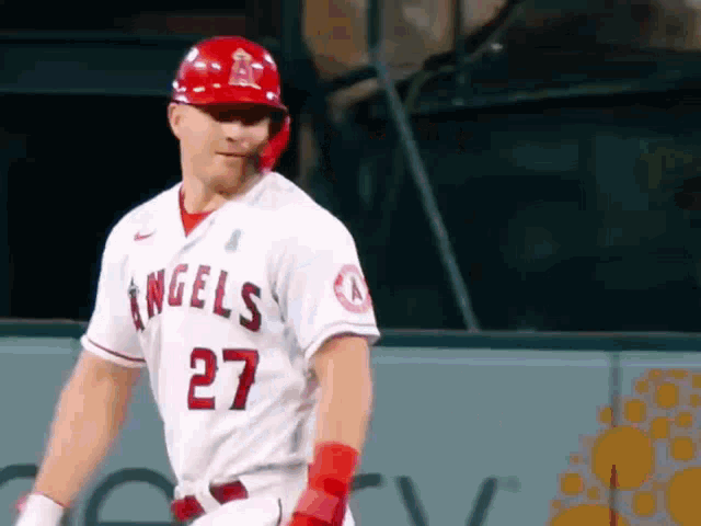 a baseball player for the angels is wearing a red helmet