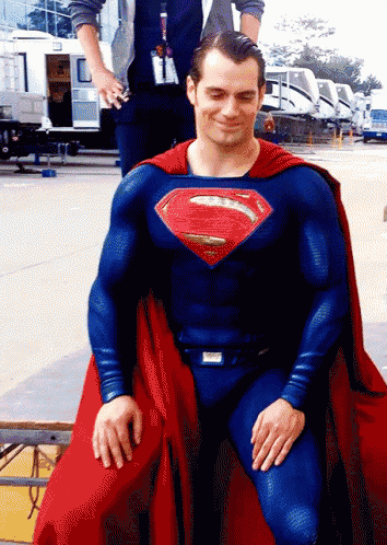 a man in a superman costume is sitting on the ground