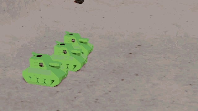 a row of green toy tanks are lined up on a concrete surface