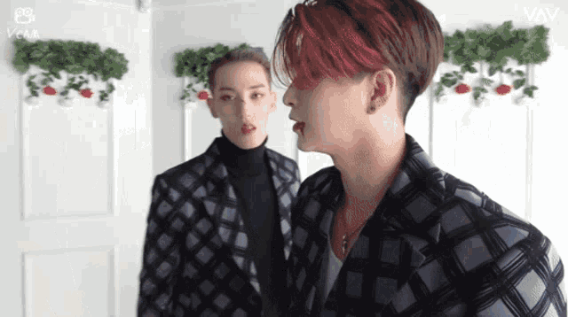 a man with red hair is standing next to another man in a plaid suit