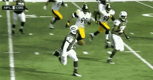 a group of football players are running on a field with a cbs logo in the corner